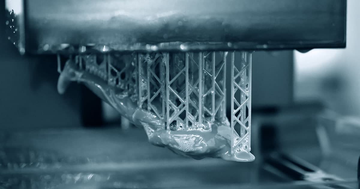 Resin model on supports beneath an SLA printer build platform