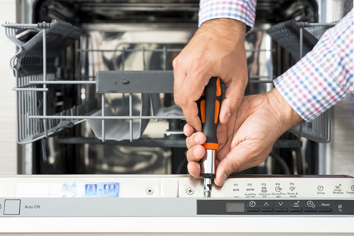 Technician repairing a dishwasher