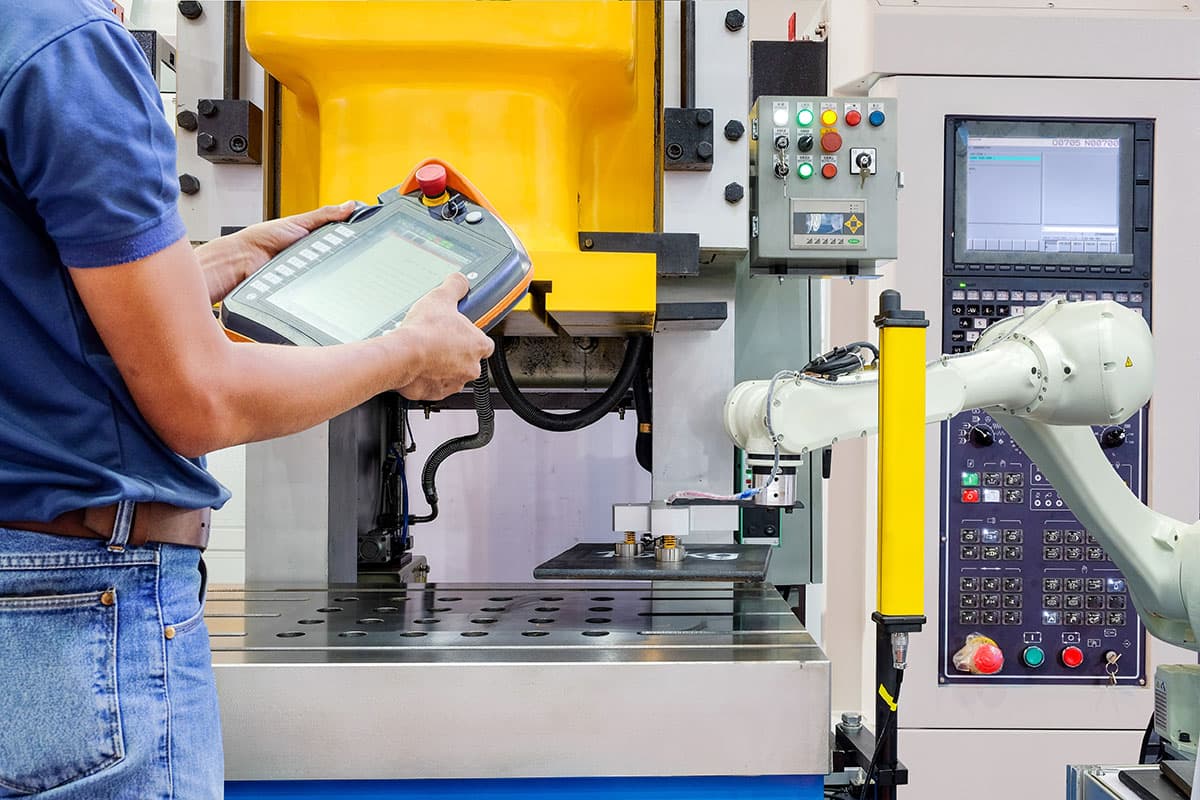 Operator programming a robot at a production station
